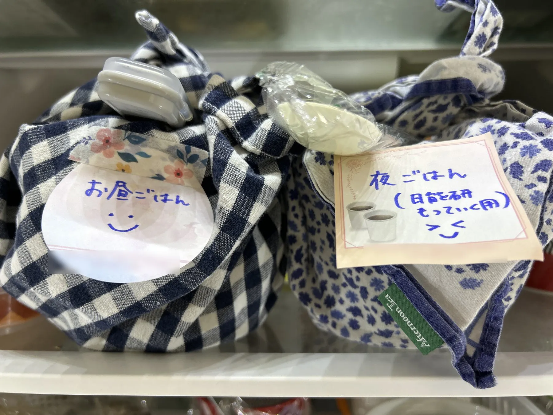 冷蔵庫で出発まで保管している2つのお弁当。付箋で昼用と夜用が分かるようにしてある